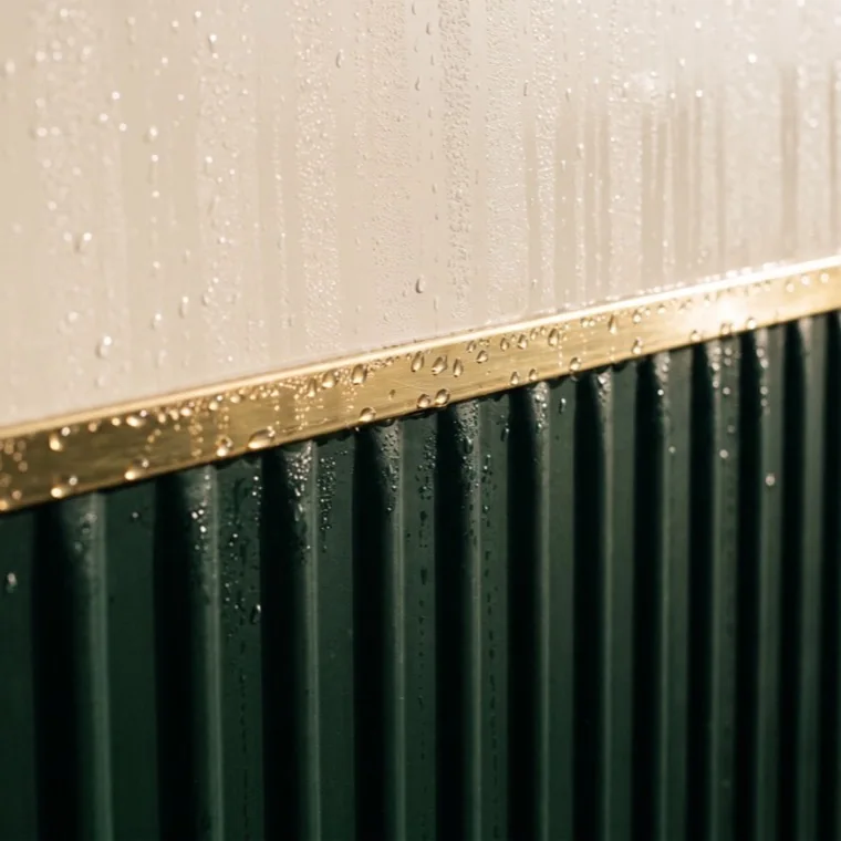 Extreme close-up of the brass pinstripe on the corrugated green flank.
