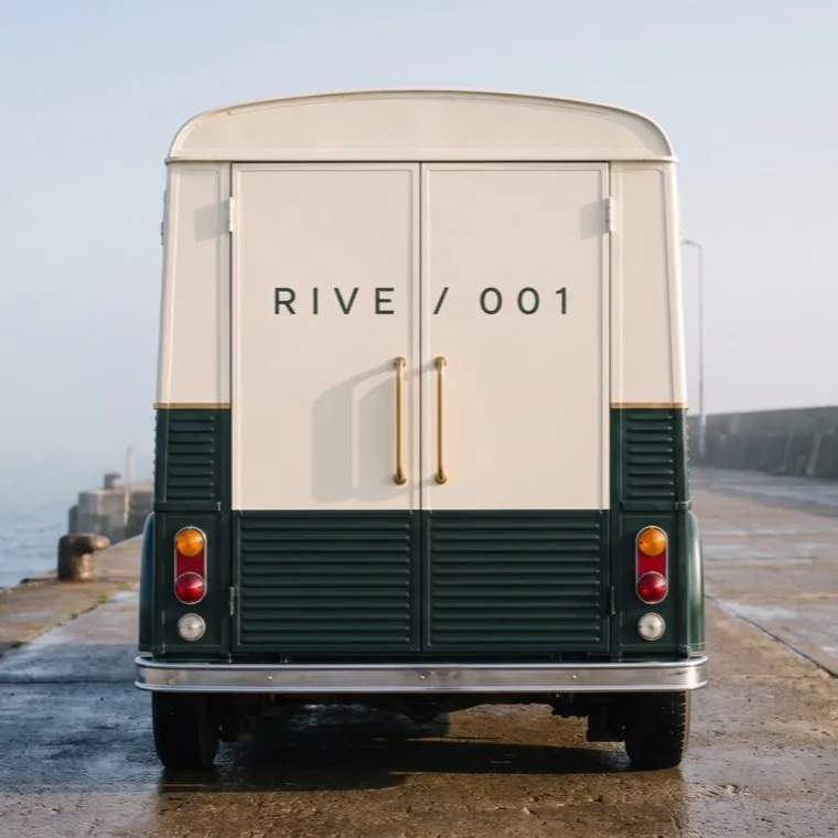 The engraved plate reading RIVE / 001 across the ivory rear doors.